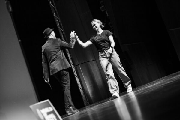 Poetry Slam Künstler tritt beim WoW Poetry Slam in NRW auf einer Bühne vor Publikum auf