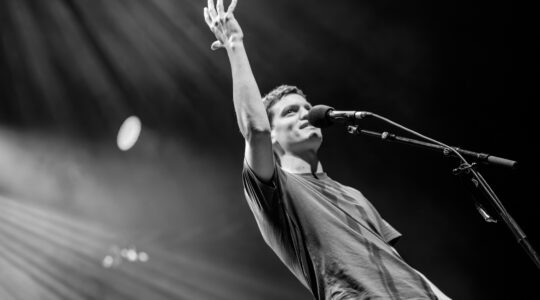 Slam Poet auf der Bühne vor großem Publikum bei einem WoW Poetry Slam NRW